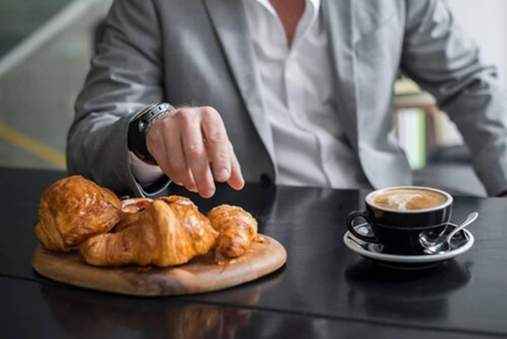 อะเดลฟี โฮเต็ล Hotel เมลเบิร์น ภายนอก รูปภาพ A man with a coffee and a pastry